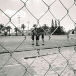 Derrière les grilles d'un terrain de sport